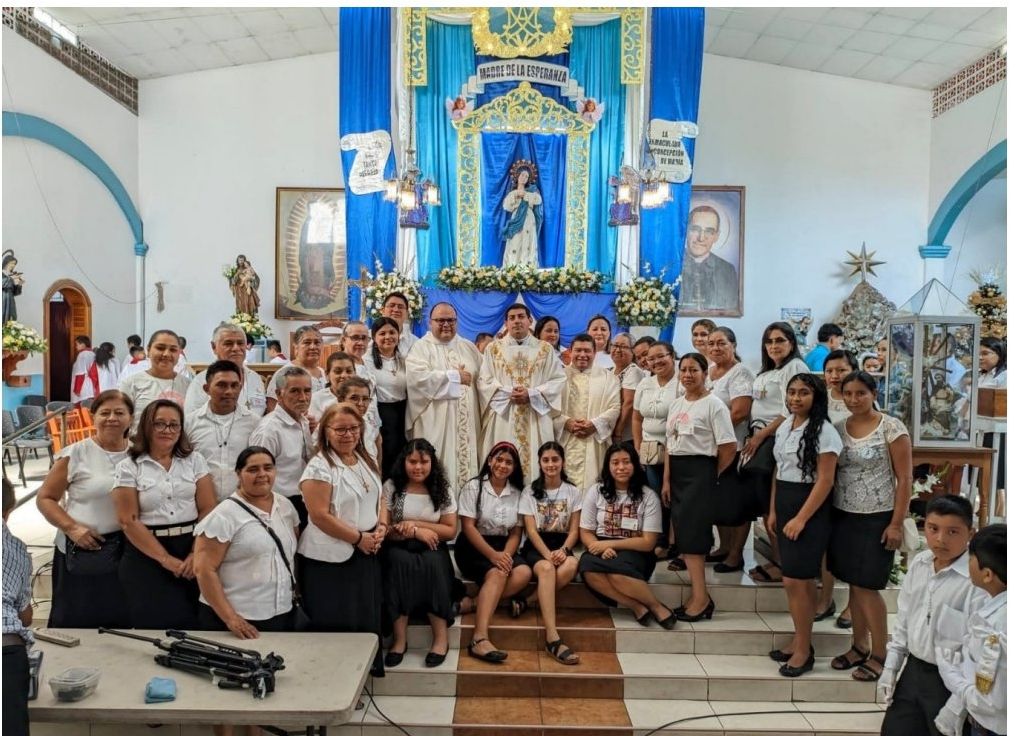 Catequistas y niñas de primera comunión frente al altar de la Inmaculada Concepción