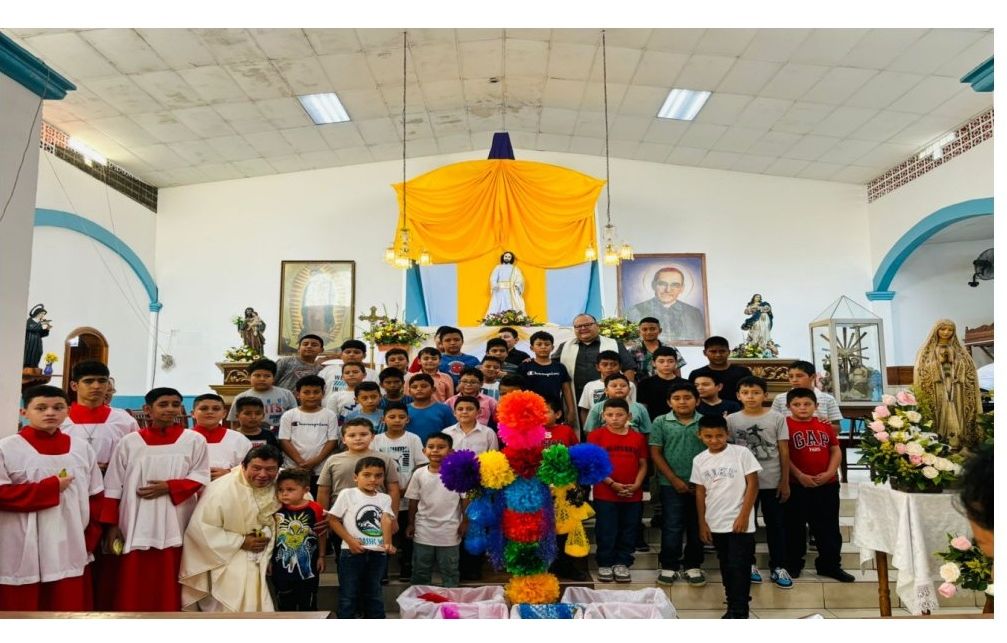 Grupo de niños de primera comunión con el sacerdote en el templo parroquial